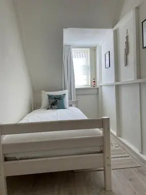 a small bedroom with a bed and a window at Have a nice stay! - Voilà! - beach at 500m- free parking in Noordwijk aan Zee