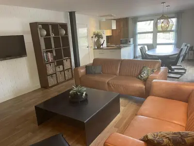 a living room with a couch and a table at Kapberg 'Om de Noord' in Warmenhuizen