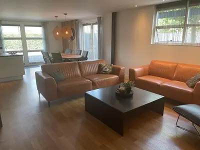 a living room with two couches and a coffee table at Kapberg 'Om de Noord' in Warmenhuizen