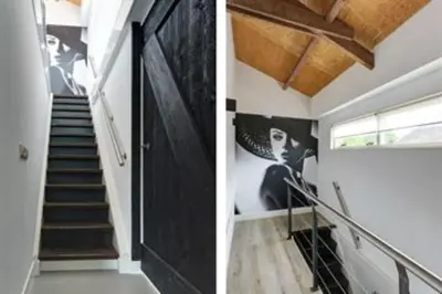a staircase in a house with a black door at Kapberg 'Om de Noord' in Warmenhuizen