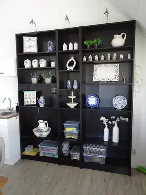 a black book shelf filled with dishes and vases at Guesthouse Wormer in Wormer