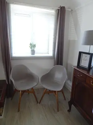 two white chairs in a room with a window at Guesthouse Wormer in Wormer