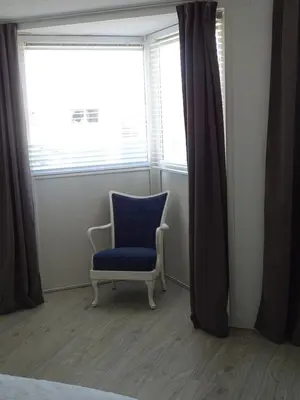 a blue chair in a room with a window at Guesthouse Wormer in Wormer
