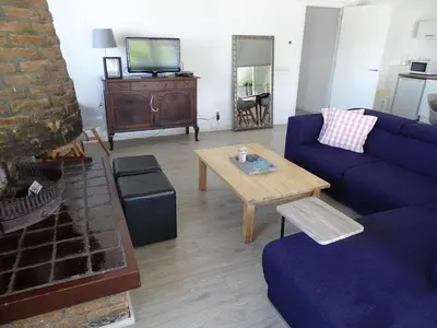 a living room with a blue couch and a table at Guesthouse Wormer in Wormer