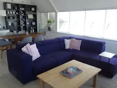 a living room with a blue couch and a table at Guesthouse Wormer in Wormer