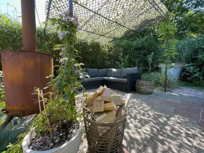 a garden with a couch and a potted plant at Duinstudio Bergen in Bergen