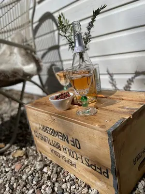 a bottle of whiskey sitting on top of a wooden box at Duinstudio Bergen in Bergen