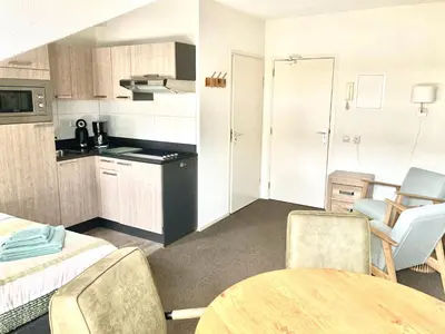 a room with a kitchen and a table and chairs at Nicolette Apartments in Katwijk
