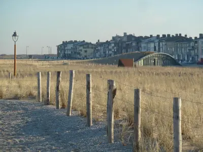 a fence in a field with buildings in the background at Nicolette Apartments in Katwijk