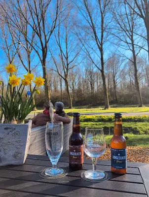 a table with two glasses and two bottles of beer at Hotel Molengroet in Noord-Scharwoude
