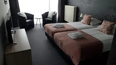 a hotel room with a bed with two towels on it at Hotel Molengroet in Noord-Scharwoude