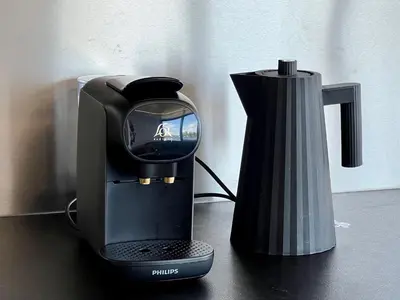 a black coffee maker and a vase on a table at NEW - Little Asia - Stunning Boathouse on a lake Near Amsterdam with Sauna in Vinkeveen