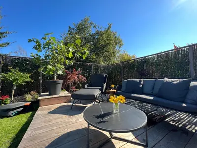 a patio with a blue couch and a table at NEW - Little Asia - Stunning Boathouse on a lake Near Amsterdam with Sauna in Vinkeveen