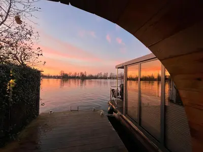 a dock with ducks on the water at sunset at NEW - Little Asia - Stunning Boathouse on a lake Near Amsterdam with Sauna in Vinkeveen