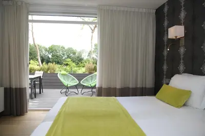 a hotel room with a bed and a balcony at Alp de Veenen Hotel in Amstelveen