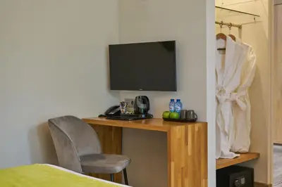 a room with a desk with a television and a chair at Alp de Veenen Hotel in Amstelveen