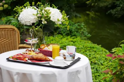 a table with a tray of food and a vase of flowers at Alp de Veenen Hotel in Amstelveen