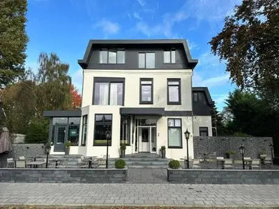 a large white house with a lot of windows at Alp de Veenen Hotel in Amstelveen