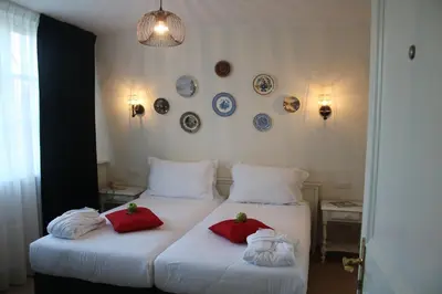 a bedroom with two beds with red pillows and plates on the wall at Alp de Veenen Hotel in Amstelveen