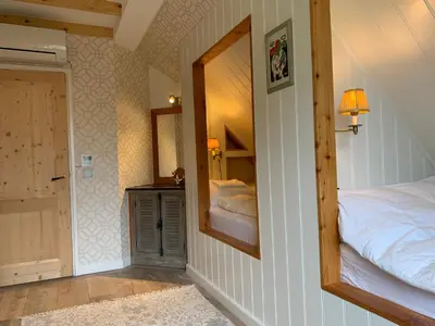 a bedroom with a mirror and a bed in it at Lovely warm Country home in Breukeleveen
