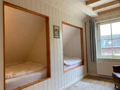 a room with two mirrors and a window at Lovely warm Country home in Breukeleveen