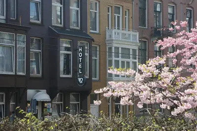 a building with a sign on the side of it with pink flowers at Aadam Wilhelmina Hotel in Amsterdam