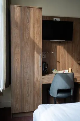 a bedroom with a desk and a chair next to a bed at Aadam Wilhelmina Hotel in Amsterdam