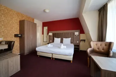 a hotel room with a bed and a chair at Aadam Wilhelmina Hotel in Amsterdam