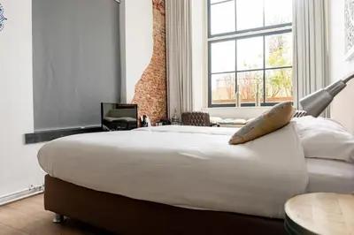 a large white bed in a room with a window at 1001 Nights Boutique Hotel in Haarlem
