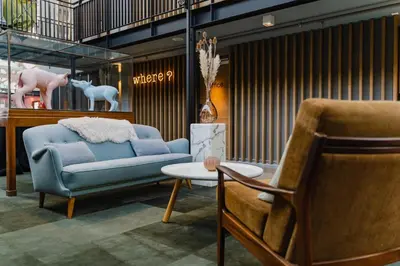 a living room with a blue couch and a table at Hotel De Hallen in Amsterdam