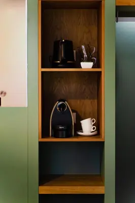 a shelf with a toaster and cups on it at Hotel De Hallen in Amsterdam