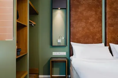 a bedroom with green walls and a bed and a mirror at Hotel De Hallen in Amsterdam