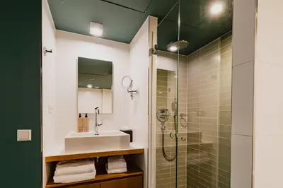 a bathroom with a sink and a shower at Hotel De Hallen in Amsterdam