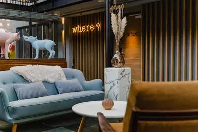 a living room with a blue couch and a table at Hotel De Hallen in Amsterdam