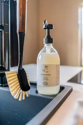 a bottle of soap and a brush on a sink at Luxury private farmhouse cottage near Amsterdam plus home cinema in Ilpendam