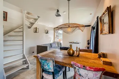 a dining room with a wooden table and chairs at Luxury private farmhouse cottage near Amsterdam plus home cinema in Ilpendam