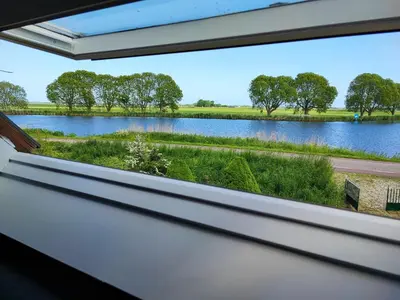 a window view of a lake from a house at Guesthouse at the Amstel river with 2BR 2BA and garden in Amstelveen