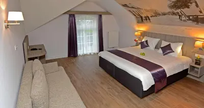 a hotel room with a large bed and a couch at Best Western City Hotel Woerden in Woerden