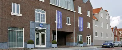 a brick building with blue signs on the side of it at Best Western City Hotel Woerden in Woerden