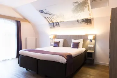 a bedroom with a bed with a painting on the wall at Best Western City Hotel Woerden in Woerden