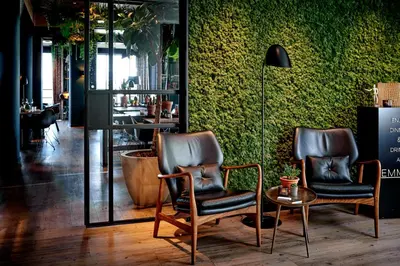 two chairs and a table in a room at Hotel Hogerhuys - adults only in Noordwijk aan Zee