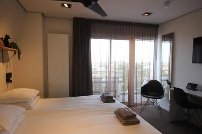 a bedroom with a large bed with two towels on it at Hotel Hogerhuys - adults only in Noordwijk aan Zee