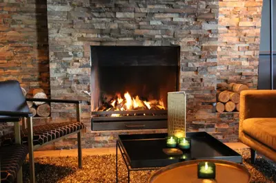 a fireplace in a living room with a fire place at Hotel Hogerhuys - adults only in Noordwijk aan Zee