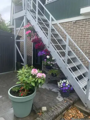 a white staircase with flowers in pots next to a house at Amsterdam Countryside met Airco ,Geweldig uitzicht, luxe keuken,wasmachine,droger,gratis fietsen in Den Ilp