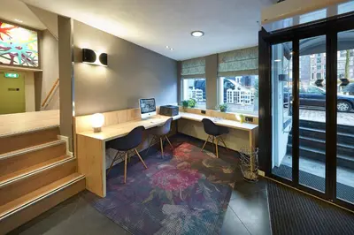 a room with a desk and chairs and a window at Nova Hotel in Amsterdam