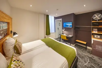 a hotel room with a large bed and a desk at Nova Hotel in Amsterdam