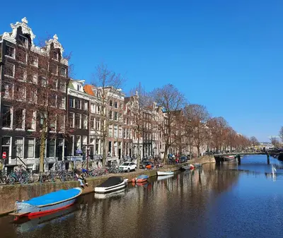 a river with boats in a city with buildings at Nova Hotel in Amsterdam
