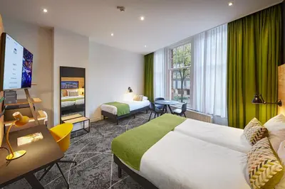 a hotel room with a bed and a flat screen tv at Nova Hotel in Amsterdam