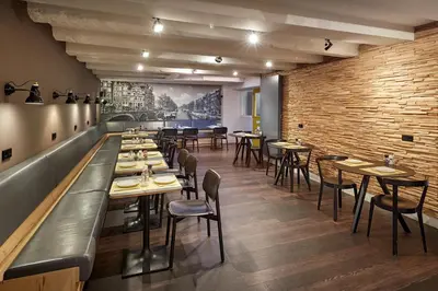 a restaurant with tables and chairs and a brick wall at Nova Hotel in Amsterdam