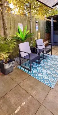 two chairs sitting on a rug on a patio at Cozy comfortable house with jacuzzi & private garden near Amsterdam in Vijfhuizen